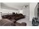 Contemporary living room with plush leather seating and a large entertainment center at 15618 Frohock Pl, Charlotte, NC 28277