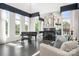 Modern living room featuring a fireplace, piano, and many large windows offering tons of natural light at 15618 Frohock Pl, Charlotte, NC 28277
