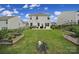 Lush backyard with a well-maintained lawn, mature trees, garden beds, and a charming patio area at 18022 Stark Way, Charlotte, NC 28278