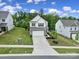 A two-story home with a well-manicured lawn and a long concrete driveway at 18022 Stark Way, Charlotte, NC 28278