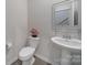 Stylish powder room features pedestal sink, toilet, and decorative mirror at 18022 Stark Way, Charlotte, NC 28278
