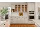 Bright kitchen with white cabinets, glass-front upper cabinets, and hardwood floors at 424 Fairhaven Ct, Waxhaw, NC 28173