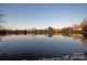 Calm lake reflecting houses and trees under a clear sky at 424 Fairhaven Ct, Waxhaw, NC 28173