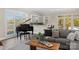 Cozy living room with grand piano, large windows and a wooden coffee table at 424 Fairhaven Ct, Waxhaw, NC 28173