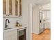 Elegant wet bar with wine cooler, quartz countertop, and black faucet at 424 Fairhaven Ct, Waxhaw, NC 28173