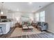 Open living room with gray sectional and armchairs at 6409 Mallow Crossing Ln, Charlotte, NC 28213