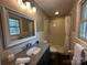Bathroom with granite vanity top, tile shower, and natural light at 6514 Highwood Pl, Charlotte, NC 28210