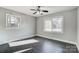 Well-lit bedroom with dark hardwood floors and two windows at 6514 Highwood Pl, Charlotte, NC 28210