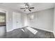 Bright bedroom with dark hardwood floors, ceiling fan and white closet doors at 6514 Highwood Pl, Charlotte, NC 28210