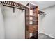 Basement closet with wood shelving and hanging rod at 6514 Highwood Pl, Charlotte, NC 28210
