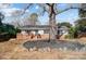 Ranch style home with large tree and stone landscaping at 6514 Highwood Pl, Charlotte, NC 28210