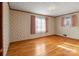Bright bedroom with hardwood floors and window with pink curtains at 700 Snuggs St, Albemarle, NC 28001