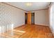 Well-lit bedroom with hardwood floors and mirrored closet doors at 700 Snuggs St, Albemarle, NC 28001