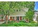 Charming two-story home featuring tan siding, brick accents, inviting front porch, and a beautifully landscaped front yard at 741 Mcalway Rd, Charlotte, NC 28211