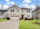 Two-story house with beige siding, a two-car garage, and a well-manicured lawn at 1414 Kings Grove Dr, York, SC 29745