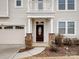 Front entrance with stone pillars, a dark brown door, and a small balcony above at 1414 Kings Grove Dr, York, SC 29745