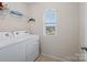 Bright laundry room features washer, dryer, and shelving at 1414 Kings Grove Dr, York, SC 29745