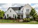 Two-story white farmhouse with landscaping and black fence at 2026 Thatcher Way, Fort Mill, SC 29715