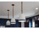 Three white pendant lights with blue accents add style to the kitchen at 2026 Thatcher Way, Fort Mill, SC 29715