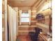 Bathroom with log walls, black toilet, and a shower at 2577 Dutch Rd, Mount Pleasant, NC 28124