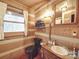Rustic bathroom with log walls, vanity, and black toilet at 2577 Dutch Rd, Mount Pleasant, NC 28124