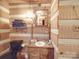 Rustic bathroom with log walls, a pedestal sink and black toilet at 2577 Dutch Rd, Mount Pleasant, NC 28124