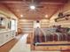 Rustic bedroom featuring a king-size bed, log walls, and a ceiling fan at 2577 Dutch Rd, Mount Pleasant, NC 28124