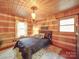 King-size bed in a rustic bedroom with log walls at 2577 Dutch Rd, Mount Pleasant, NC 28124