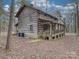 Rustic log cabin home with large wrap around porch and wooded surroundings at 2577 Dutch Rd, Mount Pleasant, NC 28124
