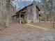 Log cabin home with stone chimney and wrap around porch. Secluded wooded lot at 2577 Dutch Rd, Mount Pleasant, NC 28124