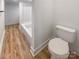 Simple bathroom with a toilet and bathtub, showcasing light wood flooring at 4914 Valley Stream Rd, Charlotte, NC 28209