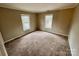 Bright bedroom with carpet flooring and two large windows at 701 Victorian Ln, Monroe, NC 28112