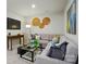 Modern living room boasts a gray sectional, decorative wall art, and a sleek glass coffee table at 7232 Hodges Meadow Ln, Charlotte, NC 28213