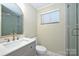 Bright bathroom featuring a modern vanity with a stone countertop, a large mirror, and a glass shower at 738 Brockbank Rd, Charlotte, NC 28209