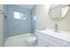 Well-lit bathroom showcases a tub and shower with blue tile, a white vanity, and updated fixtures at 738 Brockbank Rd, Charlotte, NC 28209