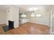 Open-concept dining area with hardwood floors, a brick accent, and seamless access to the kitchen at 738 Brockbank Rd, Charlotte, NC 28209