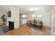 Bright dining room with hardwood floors next to a brick fireplace and open to the kitchen at 738 Brockbank Rd, Charlotte, NC 28209