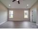 Spacious, naturally lit bedroom featuring a ceiling fan and two windows at 8690 Crestwood Dr, Mount Pleasant, NC 28124