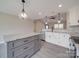 Stylish kitchen featuring white cabinets, gray kitchen island, granite countertops, and pendant lighting at 8690 Crestwood Dr, Mount Pleasant, NC 28124