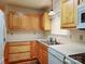 Galley kitchen featuring wood cabinets and updated appliances at 8700 Baraka Pl # D, Waxhaw, NC 28173