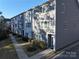 Exterior view of townhouses, showcasing landscaping and walkway at 1028 Sharon Towns Dr, Charlotte, NC 28210