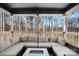 Covered deck with sectional seating and fire pit overlooking woods at 115 Brentwood Dr, Maiden, NC 28650