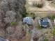 Aerial view showcases this home's setting among trees, a golf course, and a neighboring house at 124 Muirfield Dr, Kings Mountain, NC 28086