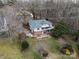 Aerial view of a home with a well-maintained backyard, patio area, and lush surrounding trees at 124 Muirfield Dr, Kings Mountain, NC 28086