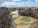 Scenic aerial shot of a golf course featuring lush greenery, a serene pond, and tree-lined fairways at 124 Muirfield Dr, Kings Mountain, NC 28086