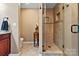 Elegant bathroom featuring a tiled walk-in shower with a glass door, and a dark wood vanity at 124 Muirfield Dr, Kings Mountain, NC 28086
