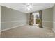 This bedroom has neutral paint, carpet, and curtains, plus a large window with natural light at 124 Muirfield Dr, Kings Mountain, NC 28086