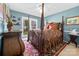 This primary bedroom has blue walls, an ornate four-poster bed and a window overlooking the yard at 124 Muirfield Dr, Kings Mountain, NC 28086
