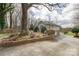 A beautiful view of a house and a tree with a retaining wall in front of the driveway at 124 Muirfield Dr, Kings Mountain, NC 28086