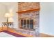 Brick fireplace with wood mantel and brass screen at 1300 Old Farm Rd, Charlotte, NC 28226